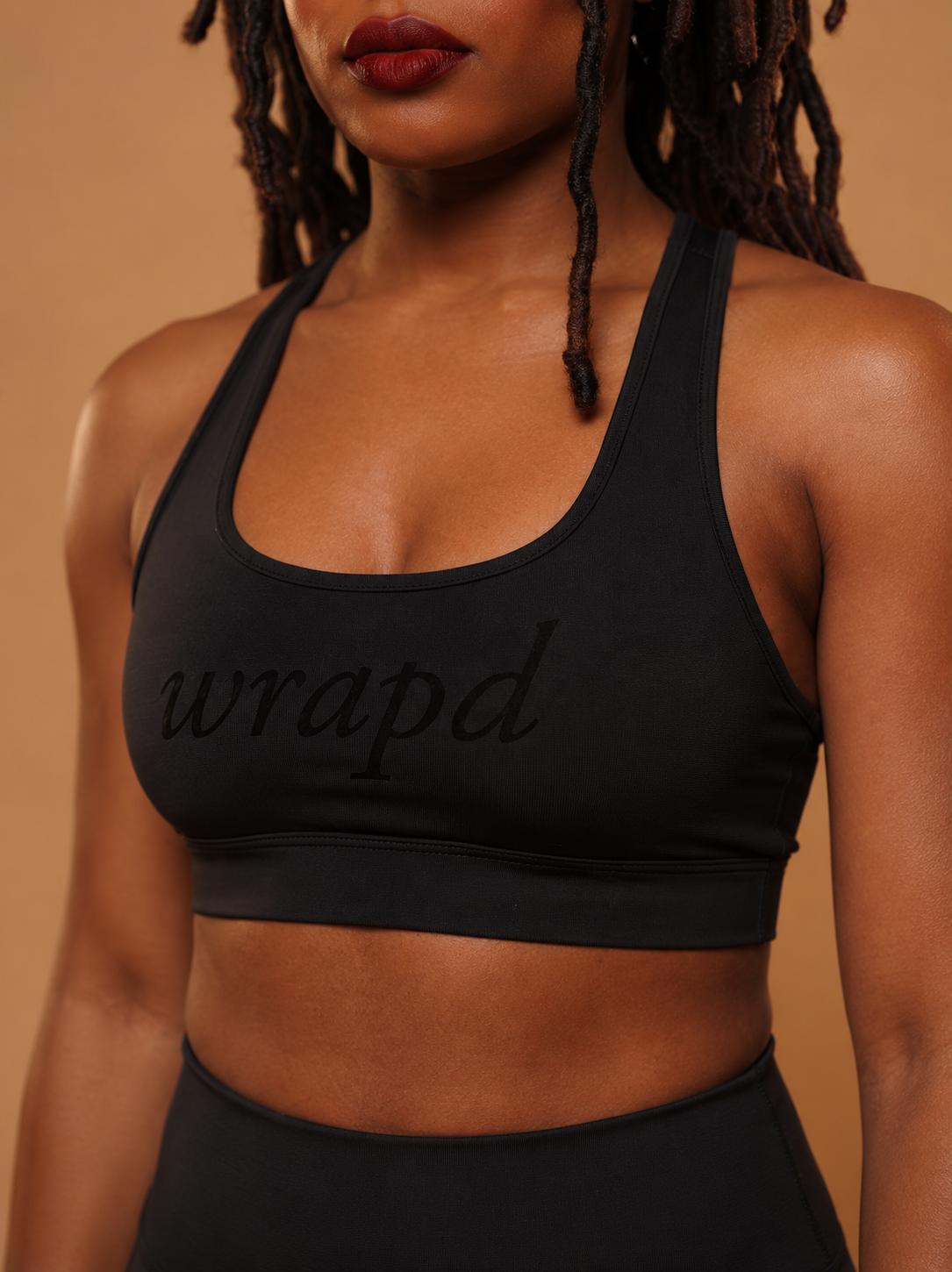 wrapd cropped sports bra in black, side view on model showing compressive fit