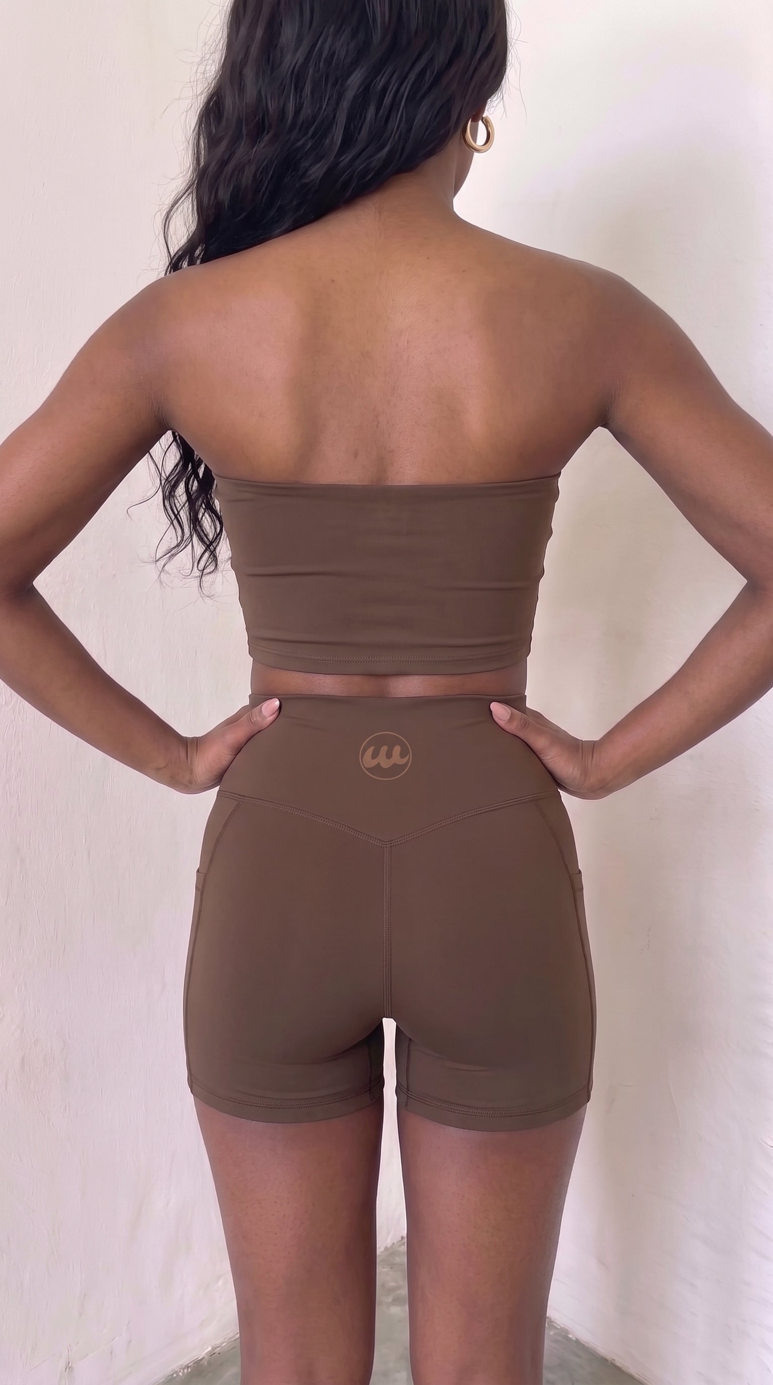 wrapd high-waisted pocket biker short in brown, back view showing logo detail