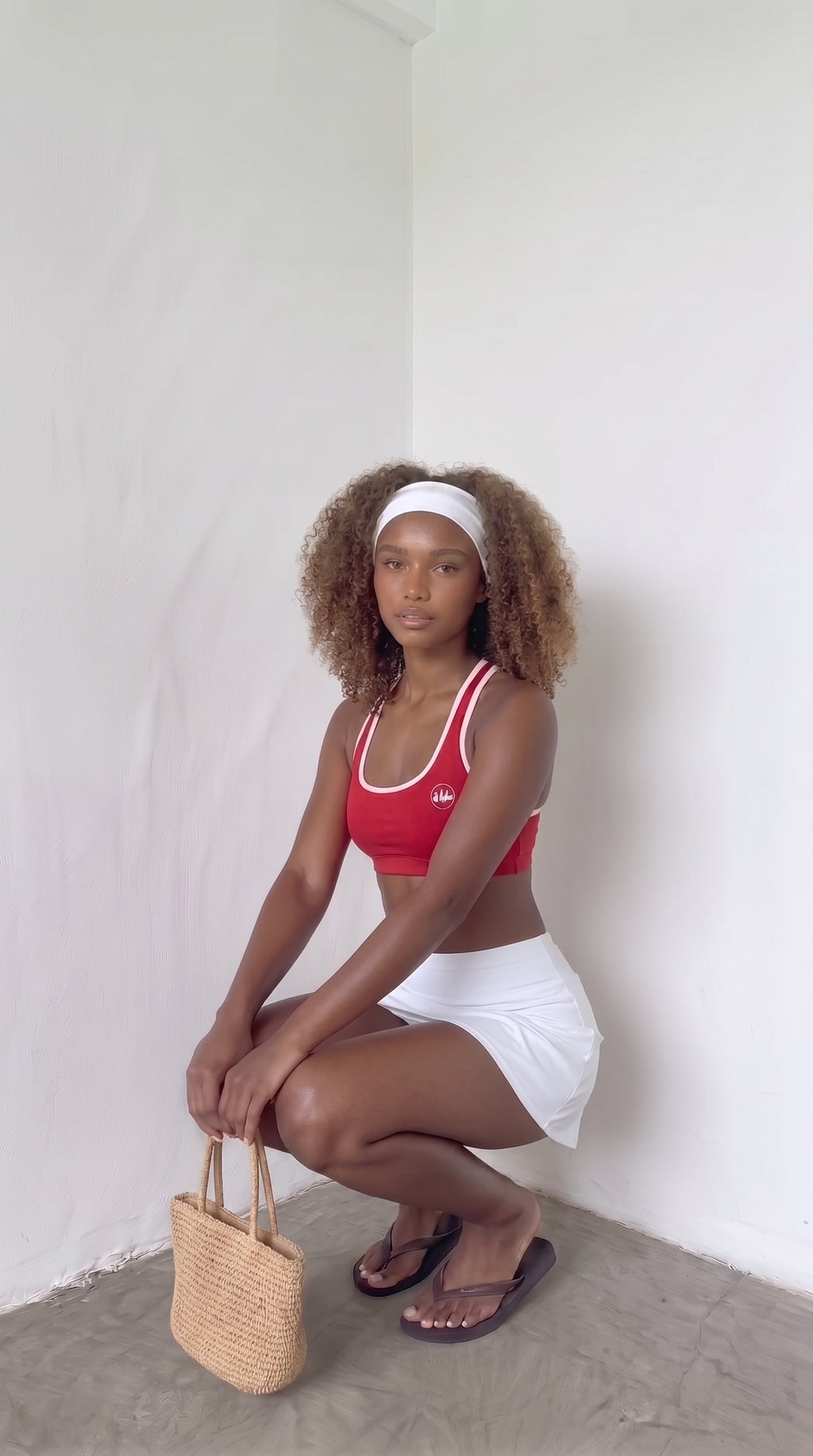 wrapd halter sports bra in red, styled pose on model