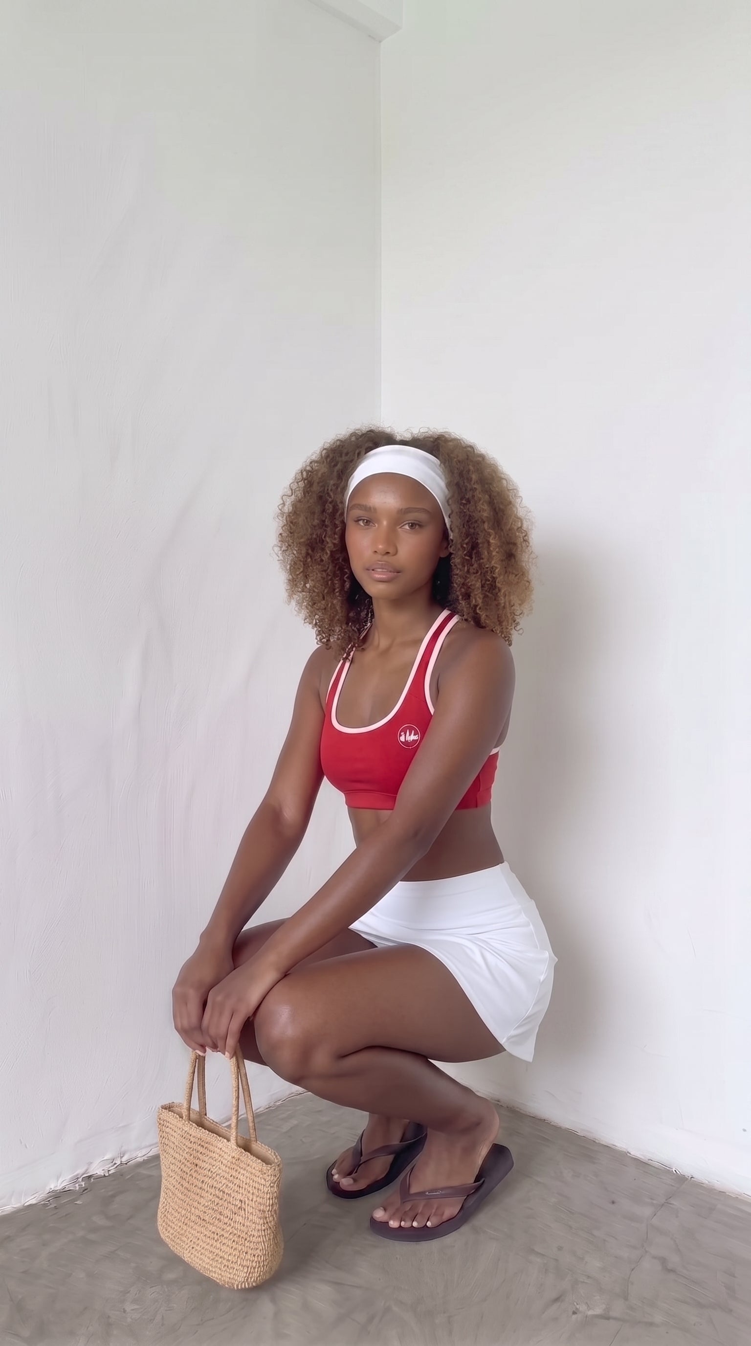 wrapd halter sports bra in red, styled pose on model