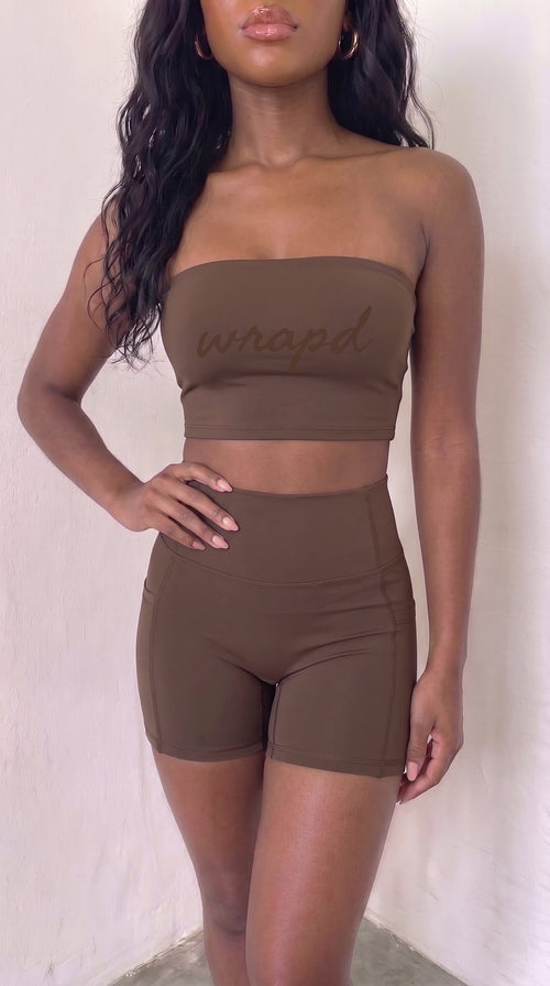 wrapd high-waisted pocket biker short in brown, front view on model